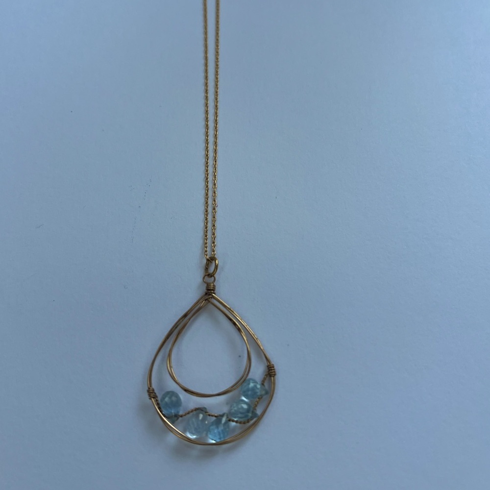 Delicate gold necklace with blue gem stones; back clasp also has blue stones
